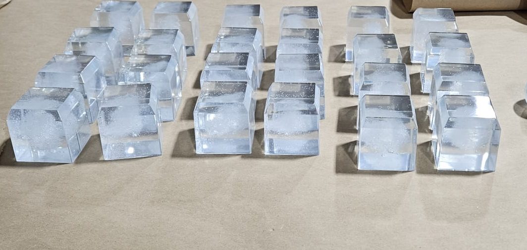 Clear reusable fake ice cubes arranged on a workshop table